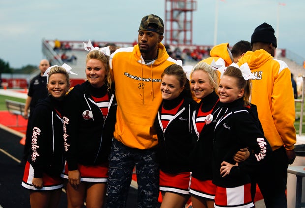 Some of the Center Grove varsity cheerleaders pose with Paul George before the start of the game.