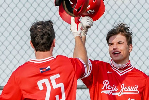 Charlie Doubet (25) celebrates with Finn O'Connor (10) after another home run in Regis Jesuit's record-breaking performance on Friday.