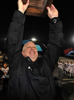 Coach Casey Taylor lifts the championship plaque. 