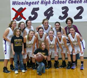 The Granbury High girls basketball team stands in front of a banner counting down coach Leta Andrews' approach to the all-time coaching wins record.