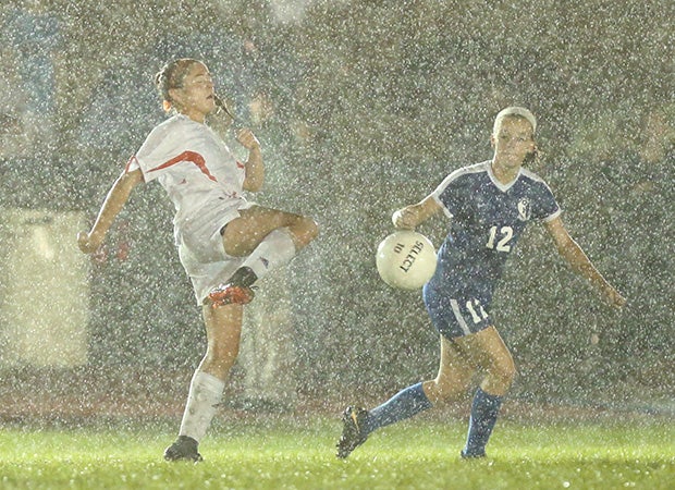 A Hackettstown (N.J.) player battles for control of the ball against a Kittatinny Regional player during a thunderstorm.