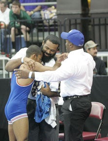 Trey Andrews gets congratulations from brother Tyrell Andrews, left, andfather Herman Andrews, right.