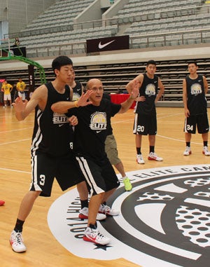 Coach Frank Allocco instructs the Chinese
players how to block out. 