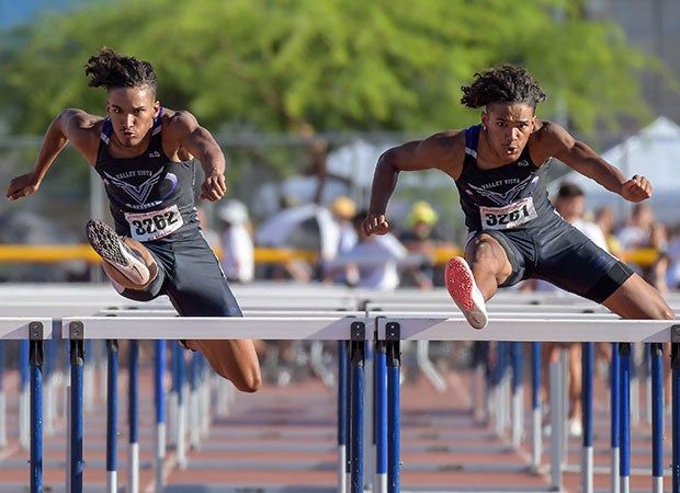 Valley Vista (Ariz.) senior twins Tyson (left) and Trenton Givens are in sync while competing in the 110-meter hurdle finals at the AIA Track and Field championships. Trenton won the race while his brother finished a close second.