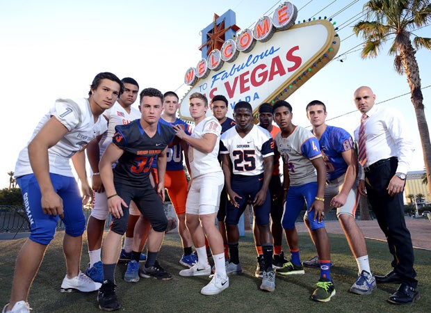 Bishop Gorman head coach Kenny Sanchez (right) poses along with 10 of his top players at the iconic sign along the Las Vegas Strip.