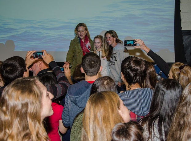 Kerri Walsh-Jennings, Polina Edmunds and Brandi Chastain are engulfed by photo takers and autograph seekers following Friday's pep rally.
