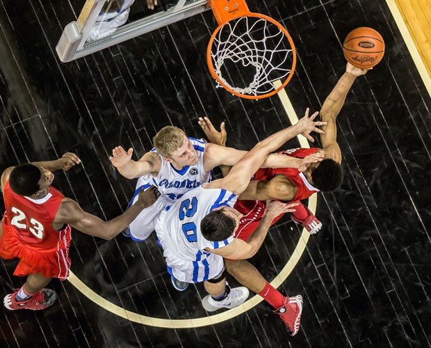 A Holmes player soars to the basket over two Covington Catholic defenders during Kentucky's KHSAA Ninth Region title game in March.