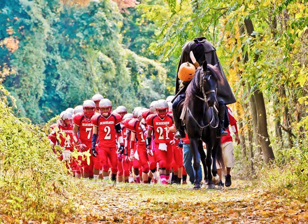 The Headless Horseman, the team mascot for Sleepy Hollow High in New York, leads football players on a march toward the field in October.