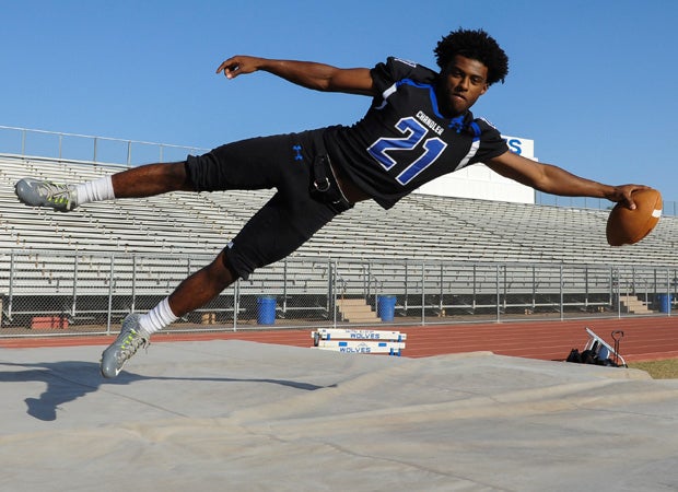 Running back Micah Reed-Campos is shown jumping over the track mat that was used for the players to land on during the photo shoot.
