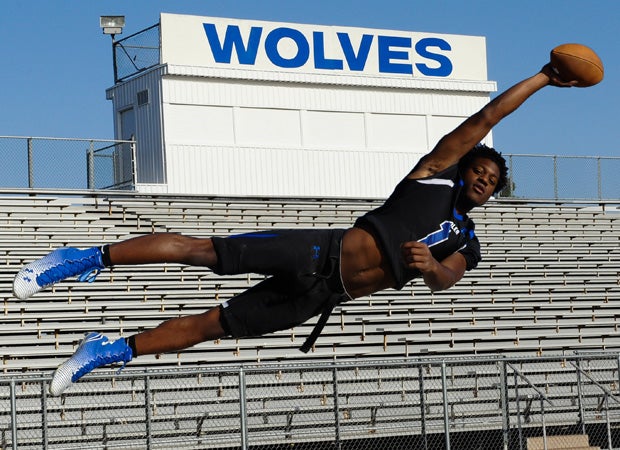 Receiver N'keal Harry soars through the air during a photo shoot at Chandler High School's football stadium in April.