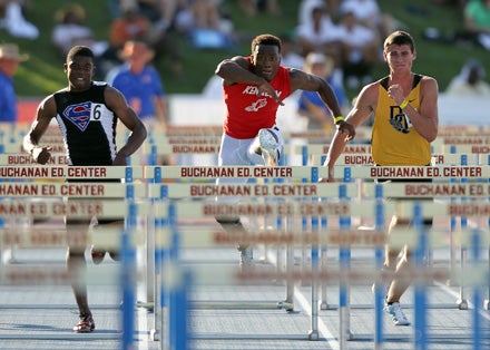 Kenneth Williams (center) ran a state season-best of 13.81 while winning his 110 hurdles heat in Friday's California State Track and Field Championship trials at Veterans Stadium on the campus of Buchanan High School.