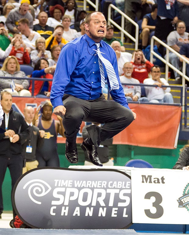 A Hickory Ridge (N.C.) coach leaps while celebrating a victory by his wrestler in the finals of the NCHSAA 3A state championships. 