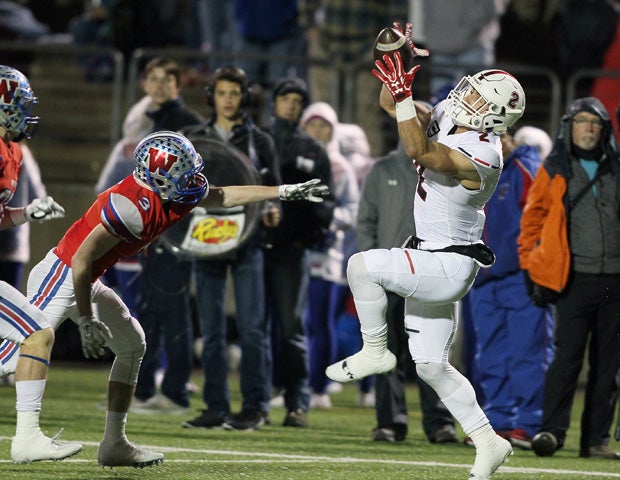 Lake Travis receiver Cade Green makes a leaping reception in front of a Westlake defender.