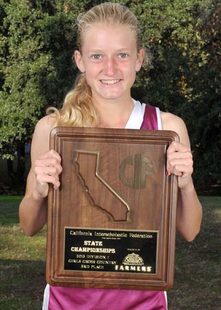 Baxter proudly displays her team's Division I third-place
trophy at the CIF State Cross Country Championships
this past November in Fresno.