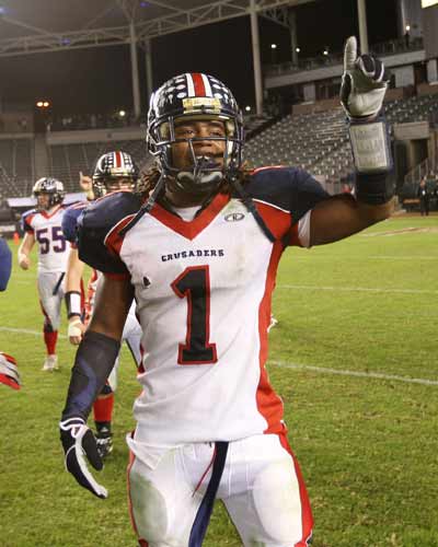 Modesto Christian QB Isaiah Burce signals team title.