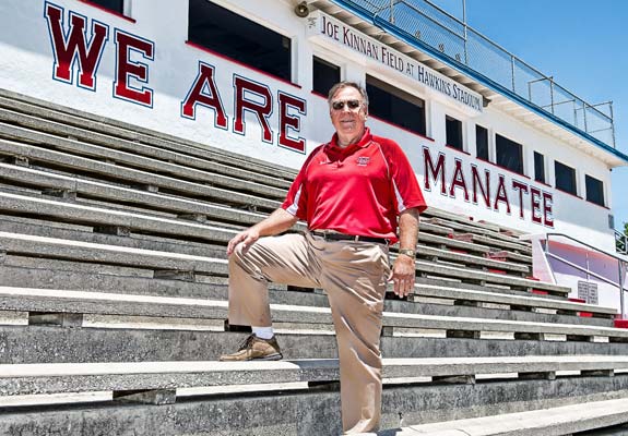 Head coach Joe Kinnan stands at Hawkins Stadium, where the field is dedicated in his honor.