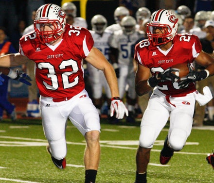 Jared Johnson (32) leads interference for Devon Moore.