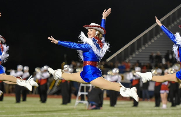 A Midway (Texas) dance performer leaps during a halftime routine in a UIL 6A Bi-District playoff football game against visiting Garland.