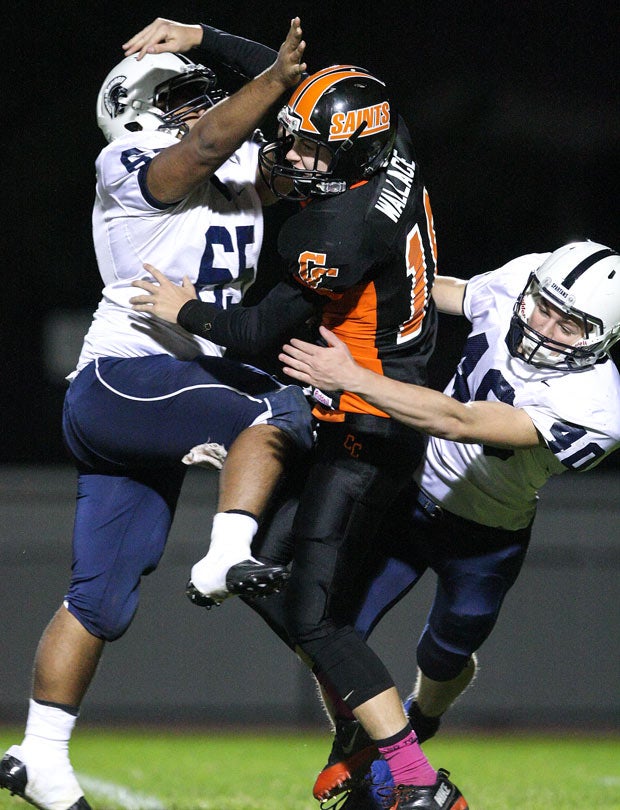 Churchville-Chili (N.Y.) quarterback Jayson Wallace throws a pass despite heavy pressure from two Gates Chili defenders.