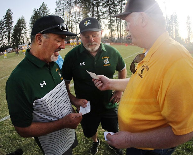 Paradise principal Jeff Marcus accepts a check from Williams athletic director Dan McDonald as Bobcats' head coach Rick Prinz looks on before the coin toss of the varsity game on Aug. 23.