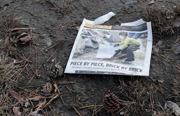 A newspaper on the ground reports on the recovery efforts by residents following the storm.
