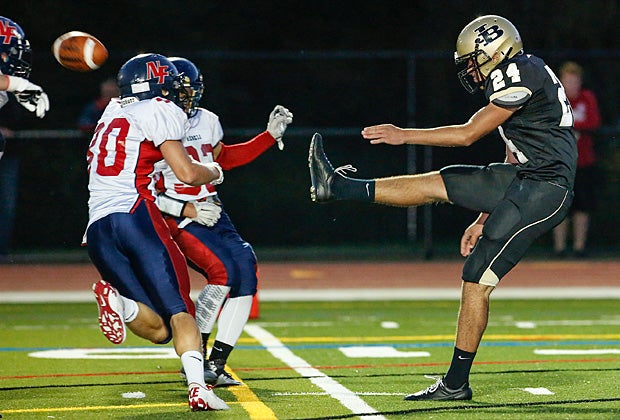 Juan Gomez of Joel Barlow (Redding, Conn.) attempts to get a kick off between New Fairfield (Conn.) defenders.