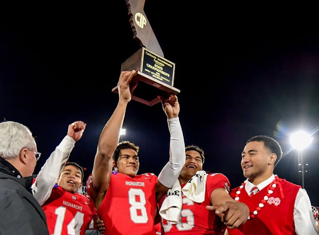 Mater Dei team captains hold up the CIF State Open Division Trophy hardware.