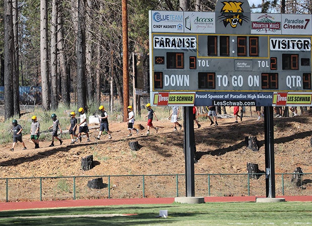The Bobcats junior varsity team runs out to the field before Thursday's practice. The scoreboard and trees around Om Wraith Field didn't escape The Camp Fire totally unscathed. 