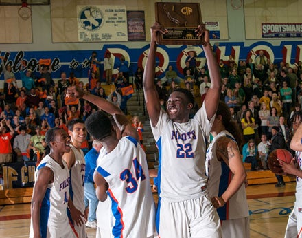 Temidayo Yussef holds up the North Region championship trophy after a win over Pinewood Saturday.