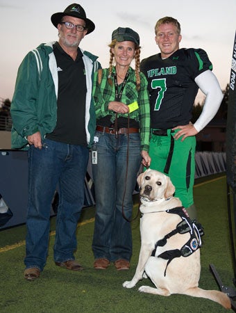 Luke and his dog Astro are shown with his father Peter
and mother Lori before a recent game.  
