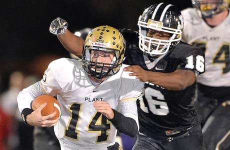 Plant quarterback Aaron Banks attempts to elude Justin Madison of Robinson. 