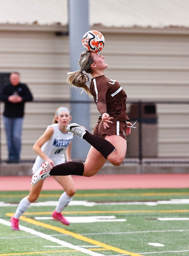 A Saint Francis (Calif.) midfielder makes a big stretch to head the ball in the Lancers' game against Valley Christian. (Photo: Jim Malone)