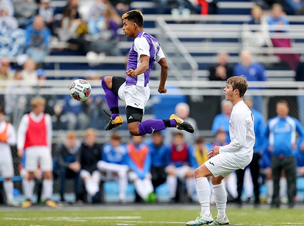 A North Kansas City (Mo.) player soars pass a Rockhurst player while advancing the ball during a MSHSAA Class 5 quarterfinal match.