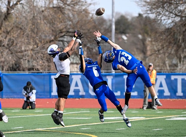 Mesa Ridge's Isaiah Jones hauls in a catch over the outstretched arms of Broomfield's Brendan Fritch and Brent Harris in the Colorado Class 4A quarterfinal. Broomfield won the game 38-6. (Photo: Derek Regensburger)