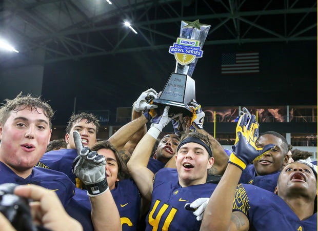 St. Thomas Aquinas (Fla.) players hoist the Geico State Champions Bowl Series trophy following their victory over Bingham (Utah) at The Star in Texas.