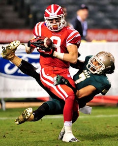 Mater Dei receiver Nikolas Little makes a
touchdown catch in front of a Poly defender.