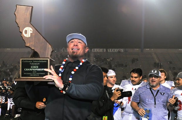 Clayton Valley coach Tim Murphy proudly holds up State Division 2-AA championship trophy in December, 2019.