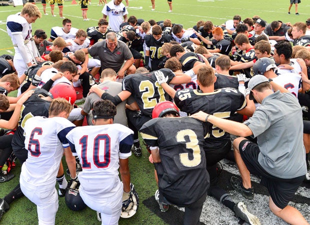 Players and coaches from Horizon Christian Academy (Calif.) and Santa Fe Christian gather for a prayer during a junior varsity game. 