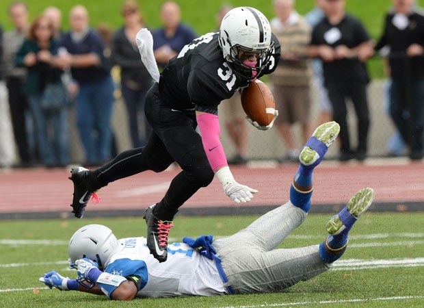 Middletown (Conn.) receiver Collin McCarthy is tripped up by a West Haven defender.