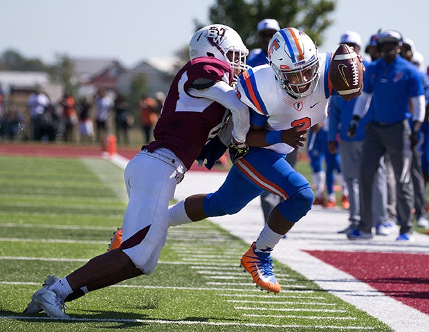 East St. Louis (III.) quarterback Christian Perez reaches toward the end zone while pursued by a Belleville West defender.