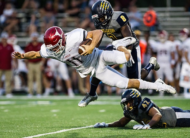 Lambert (Ga.) quarterback Bobby Gabriel is sent flying on a hit by a Wheeler defender.