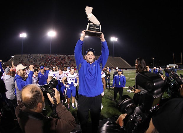 Kris Richardson holds up his fourth CIF State championship trophy on Dec. 14 at Cerritos College following a 21-14 overtime win over Cathedral Catholic. 