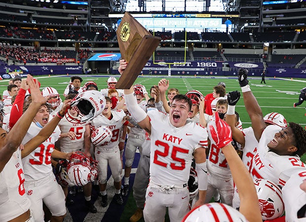 Katy linebacker Shepherd Bowling proudly hoists the state championship trophy surrounded by teammates. 