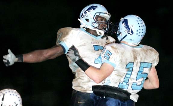 Andre Poe (7) and T.J. Gill (15) celebrate during North Penn's 43-13 win at Quakertown on Friday.