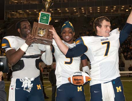Moeller players raise the trophy while celebrating their victory on Saturday.