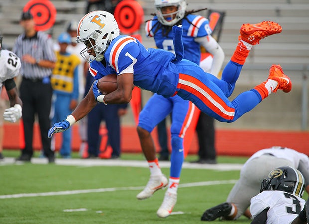 East St. Louis (III.) running back Perez Hall soars while carrying against Glenbard North.