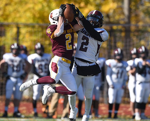 A South Windsor (Conn.) player (left) and a Farmington player battle for control of a pass.