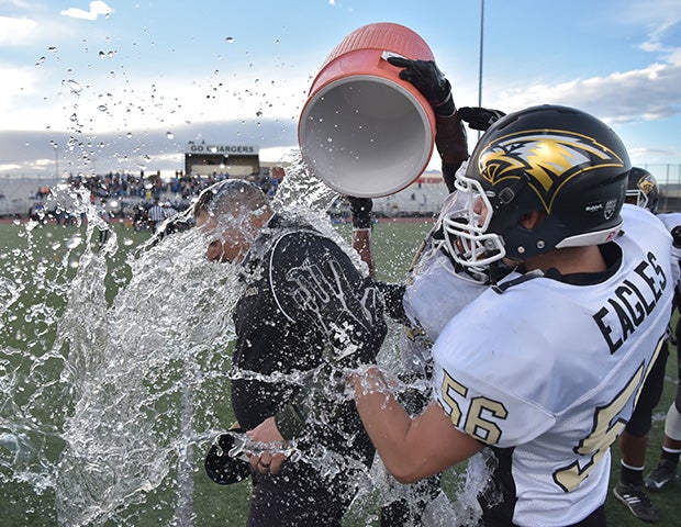 Spring Mountain (Nev.) head coach Aaron Masden is doused with water by his players while celebrating their victory in the NIAA Class 1A state championship game.