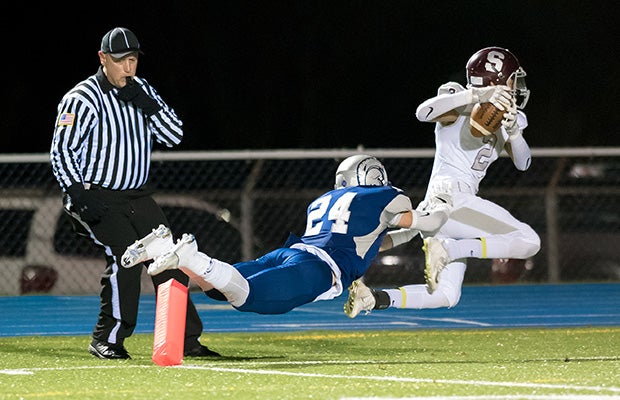 State College (Pa.) receiver Noah Woods drags McDowell cornerback Tim Romanski across the goal line in a PIAA state playoff game.