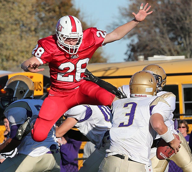 Sean Abernathy of Staunton (Ill.) leaps towards the Carlyle (Ill.) quarterback.